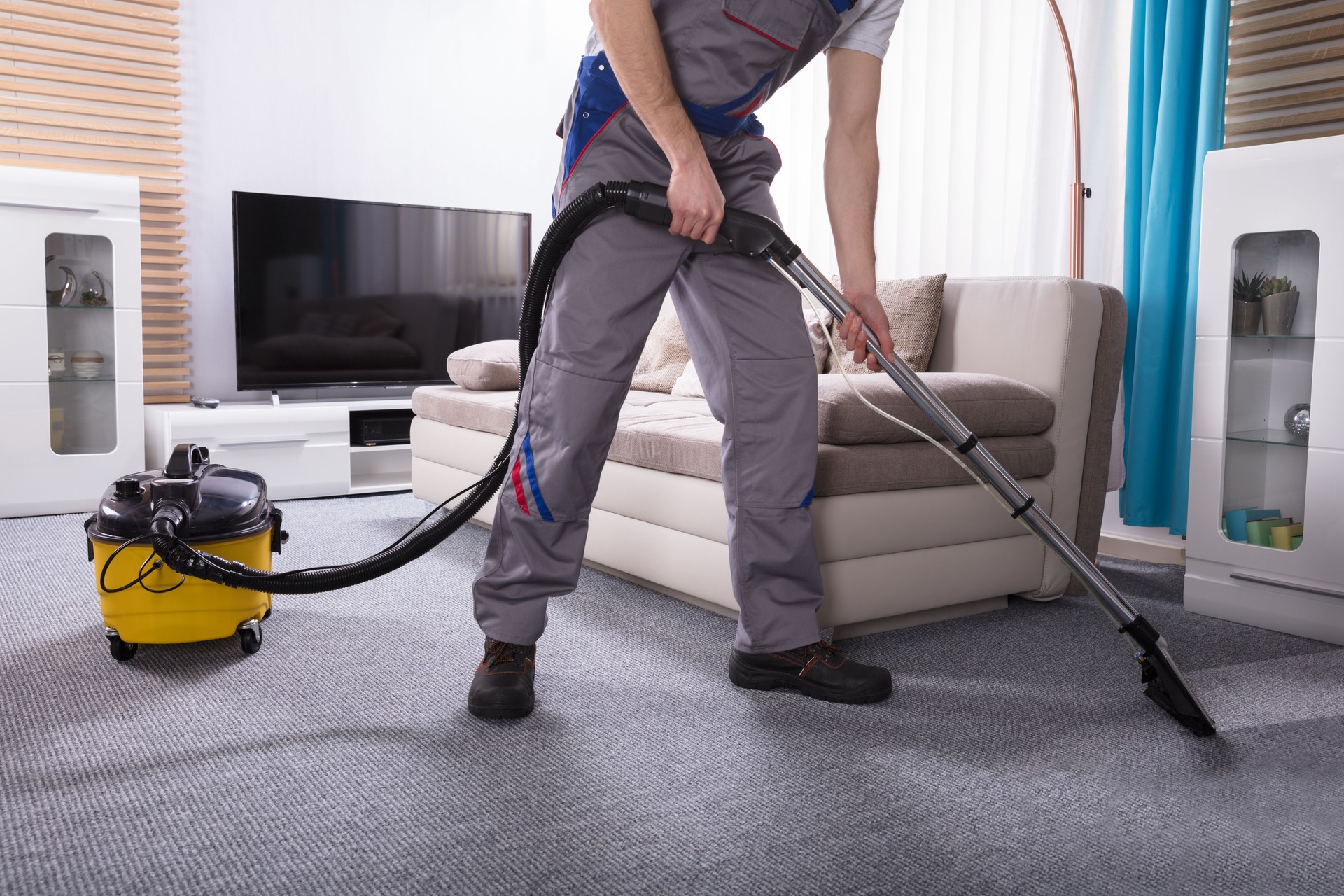 Person Cleaning Carpet With Vacuum Cleaner